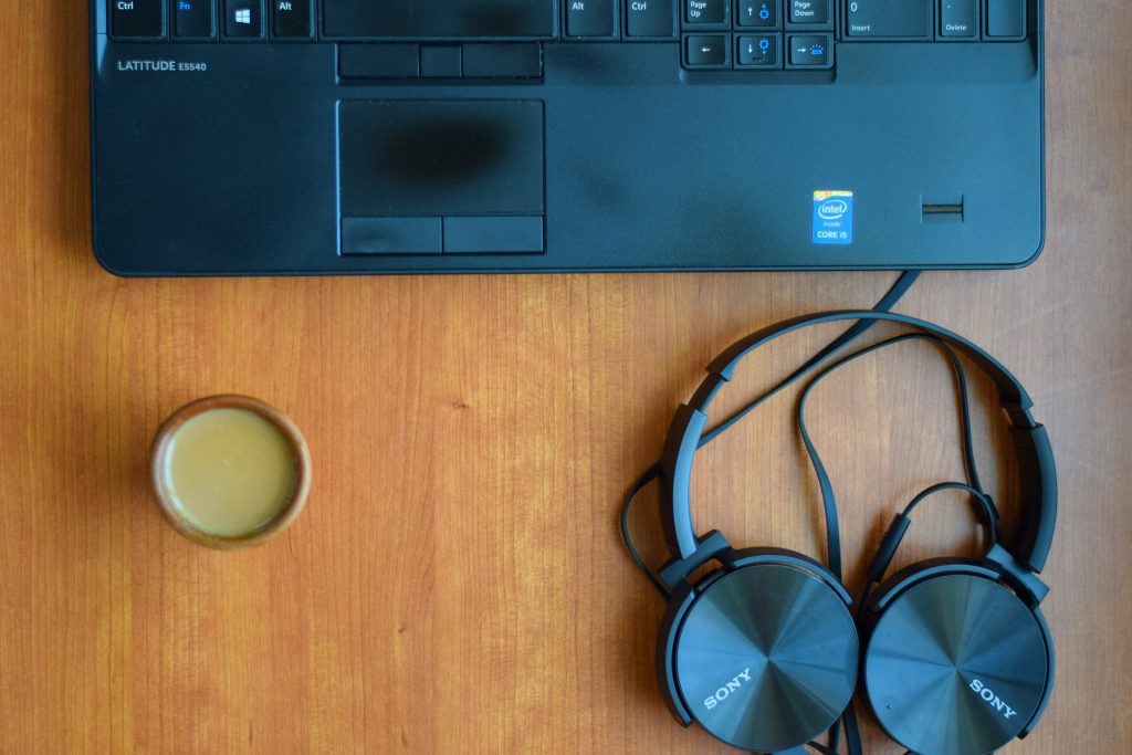 image of a laptop keyboard and headphone and mug